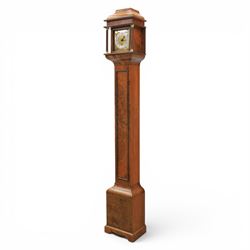 Early 20th century walnut small longcase clock, brass dial with silvered Roman numeral chapter ring and pierced black hands, the figured walnut case with shaped projecting hood, long moulded trunk door and stepped plinth base