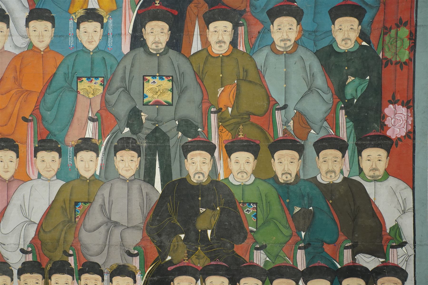 Large and impressive Chinese ancestral portrait, late Qing dynasty, gouache on stitched canvas with gilded highlights, showing thirty-eight sitters across four registers, the principal ancestors depicted before an altar table holding various ritual items, each in official dress and many wearing Golden Pheasant (Second-rank) and Silver Pheasant (Fifth-rank) Mandarin squares or 'buzi', overall 190cm x 131cm 