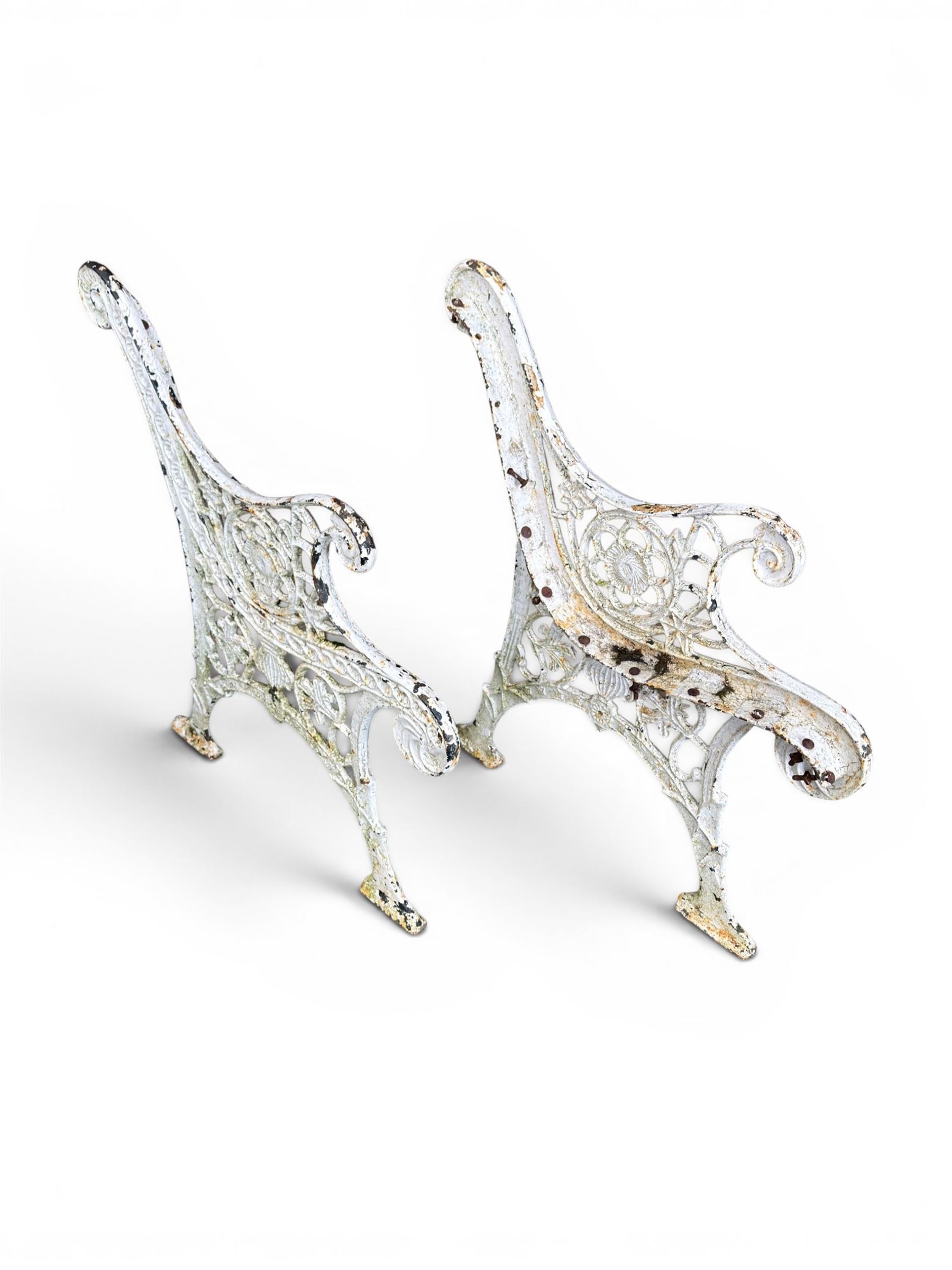 Pair of ornate painted cast iron bench ends, painted in white finish