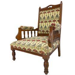 Early 20th century armchair, back and sprung seat upholstered in Art Nouveau patterned fabric, raised on ring turned supports, the frame with all-over reeded decoration