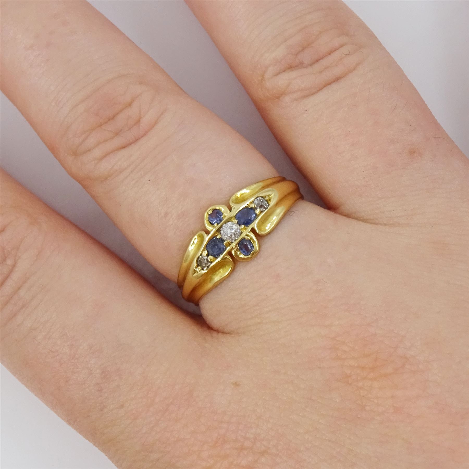 Victorian 18ct gold sapphire and diamond ring, three old cut and single cut diamonds, the principal diamond with four oval cut sapphire surround, to a ridged design shank, Birmingham 1899
