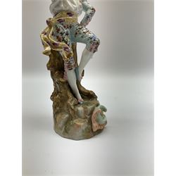 Pair of German porcelain figures, modelled as a man playing the flute and the woman dancing with a flan, upon naturalistically modelled circular base with C scroll detail, blue underglaze mark beneath and impressed 'EBS 7265', H25.5cm