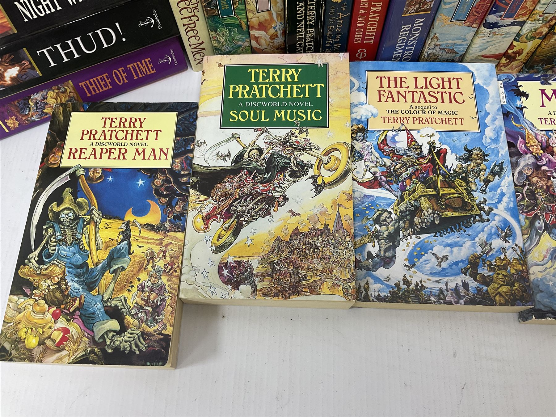 Collection of books by Terry Pratchett, of mostly Discworld interest, to include hardback edition of Going Postal, and further books such as Men at Arms, Sourcery, Small Gods etc 