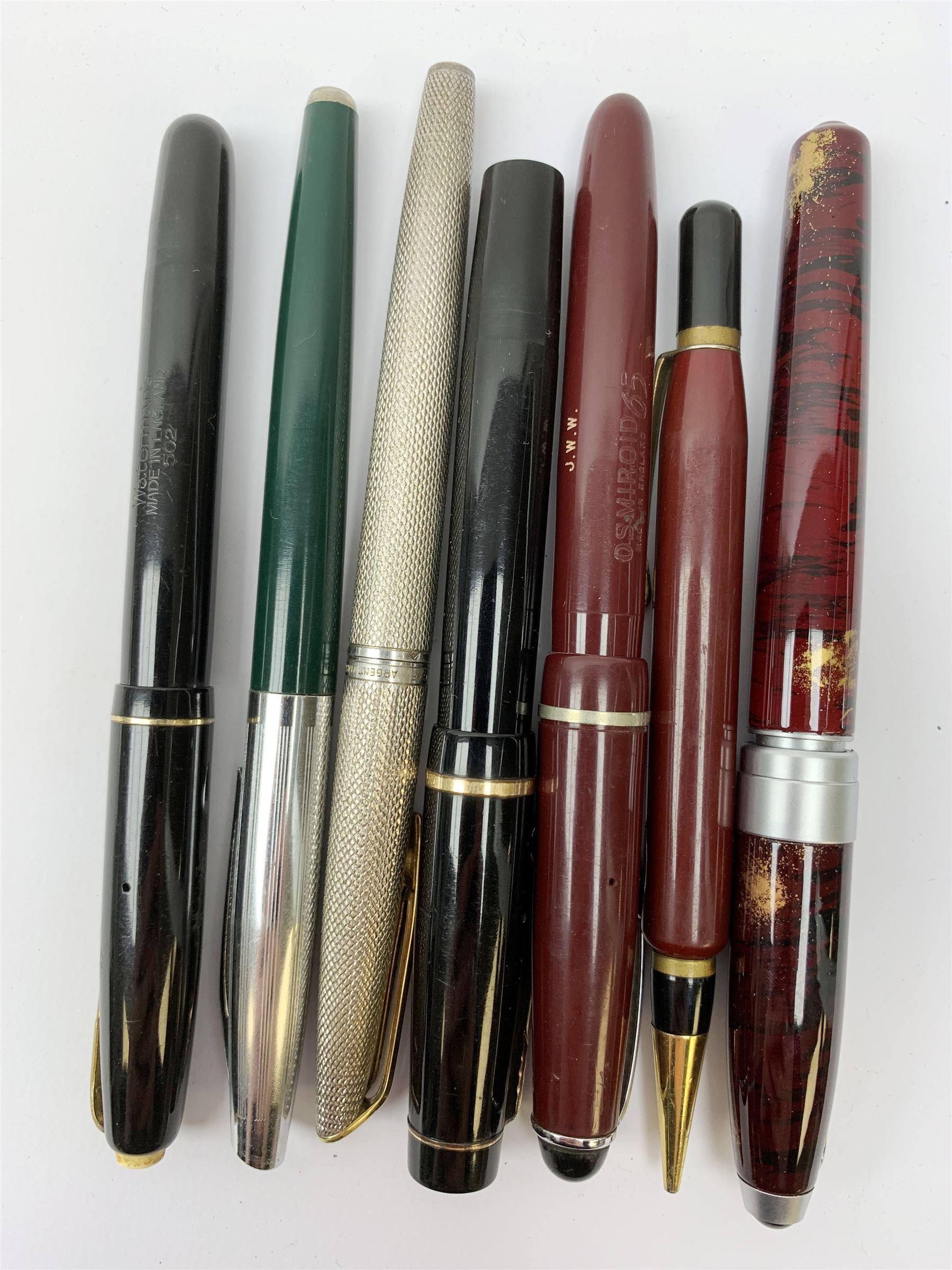 A Croxley Dickinson fountain pen, with black resin body, lever fill action and nib marked 14ct, together with two Waterman's pens, comprising a 502 with black resin body, lever fill action and nib marked 14ct, and an Argent Massif with engine turned decoration to body and nib marked 18K, an Osmiroid fountain pen with burgundy resin body and lever fill action, two further fountain pens, and a propelling pencil. (7). 