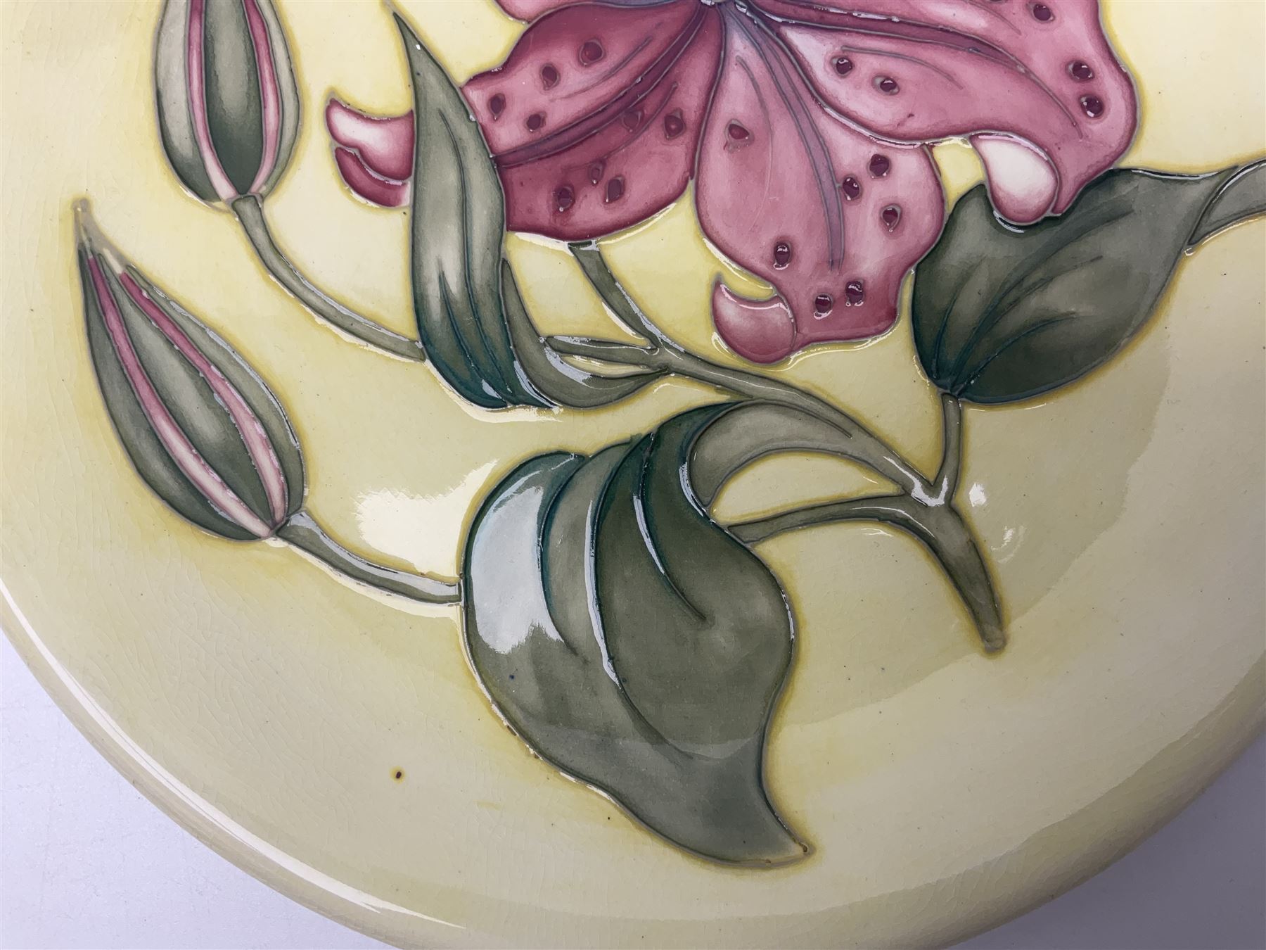 Moorcroft Tiger Lily pattern plate on a yellow ground, with painted and impressed mark beneath, D26cm