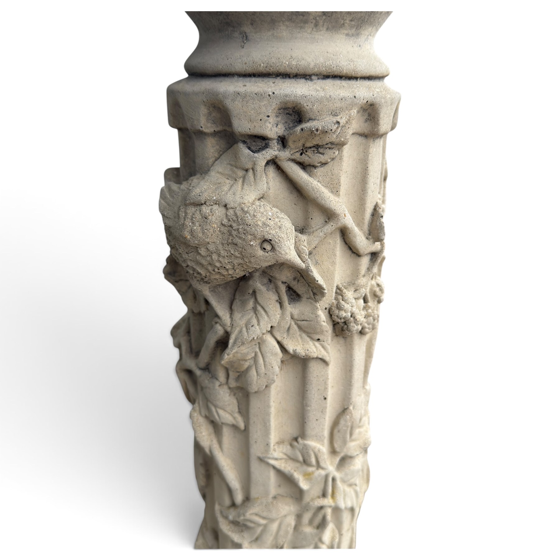 Weathered cast stone birdbath, the kylix shaped bowl with fluted body, raised on a fruiting foliate vine decorated fluted pedestal with upper knop and bird and fieldmouse motifs, shaped square base with scroll feet