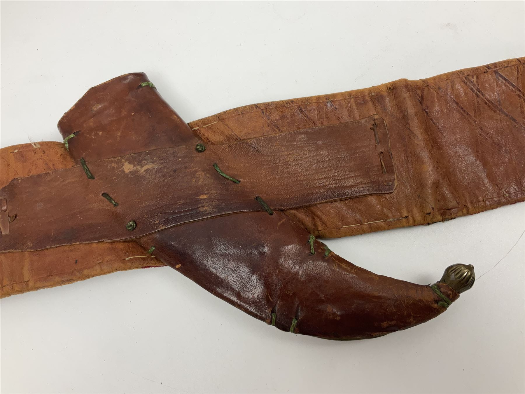 Late 19th century Yemeni Tuza jambiya as worn by religious elite, the 20.5cm curving blade with raised medial ridge, the horn hilt with pique style studwork, in a leather wrapped wooden scabbard with pierced metal mount and leather belt applied with embroidered 'gold' and 'silver' thread work panel; dagger L36cm overall, belt L84cm