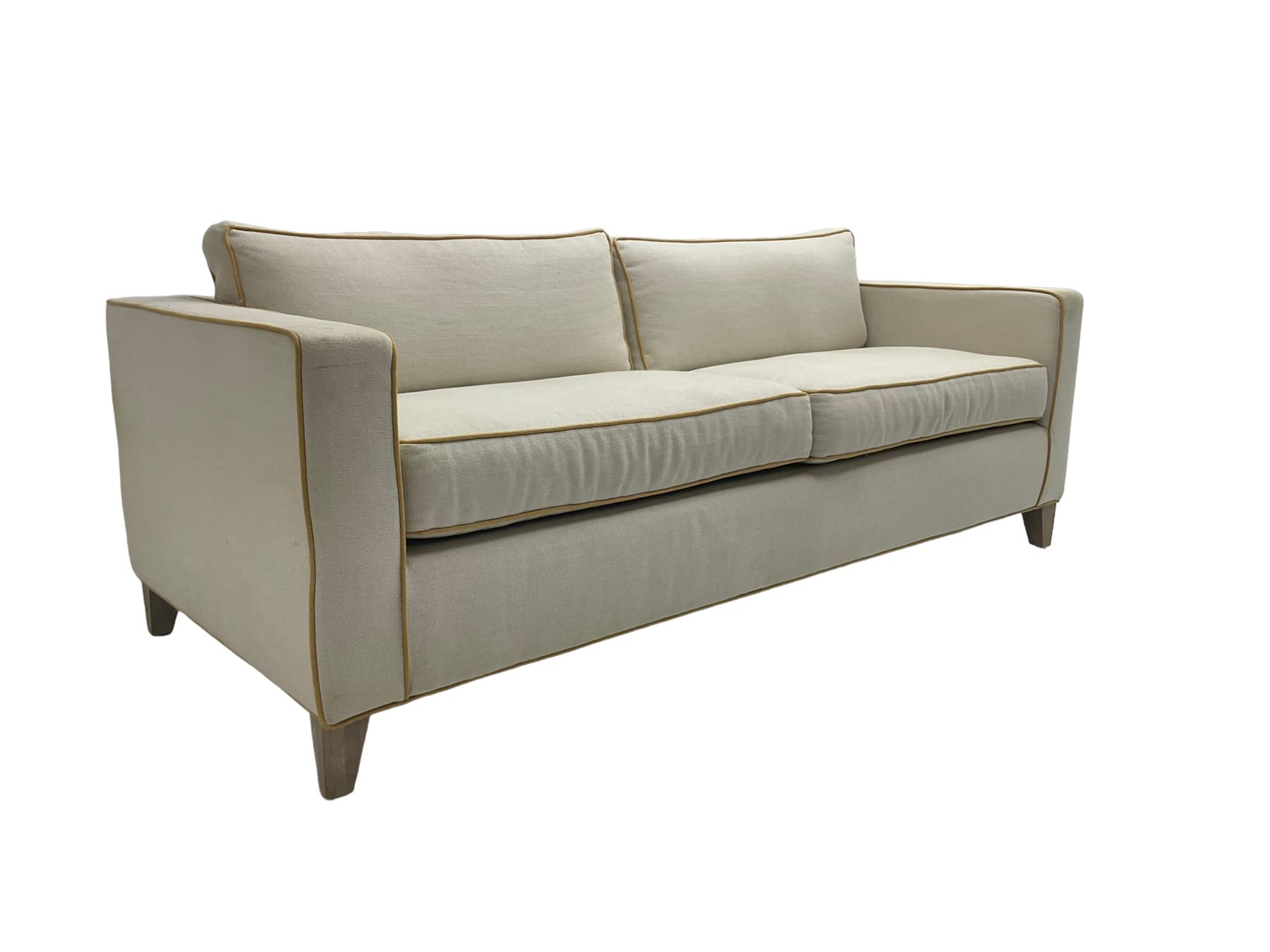 Neptune - pair three seat 'Shoreditch' sofas,  upholstered in cream fabric with yellow stringing