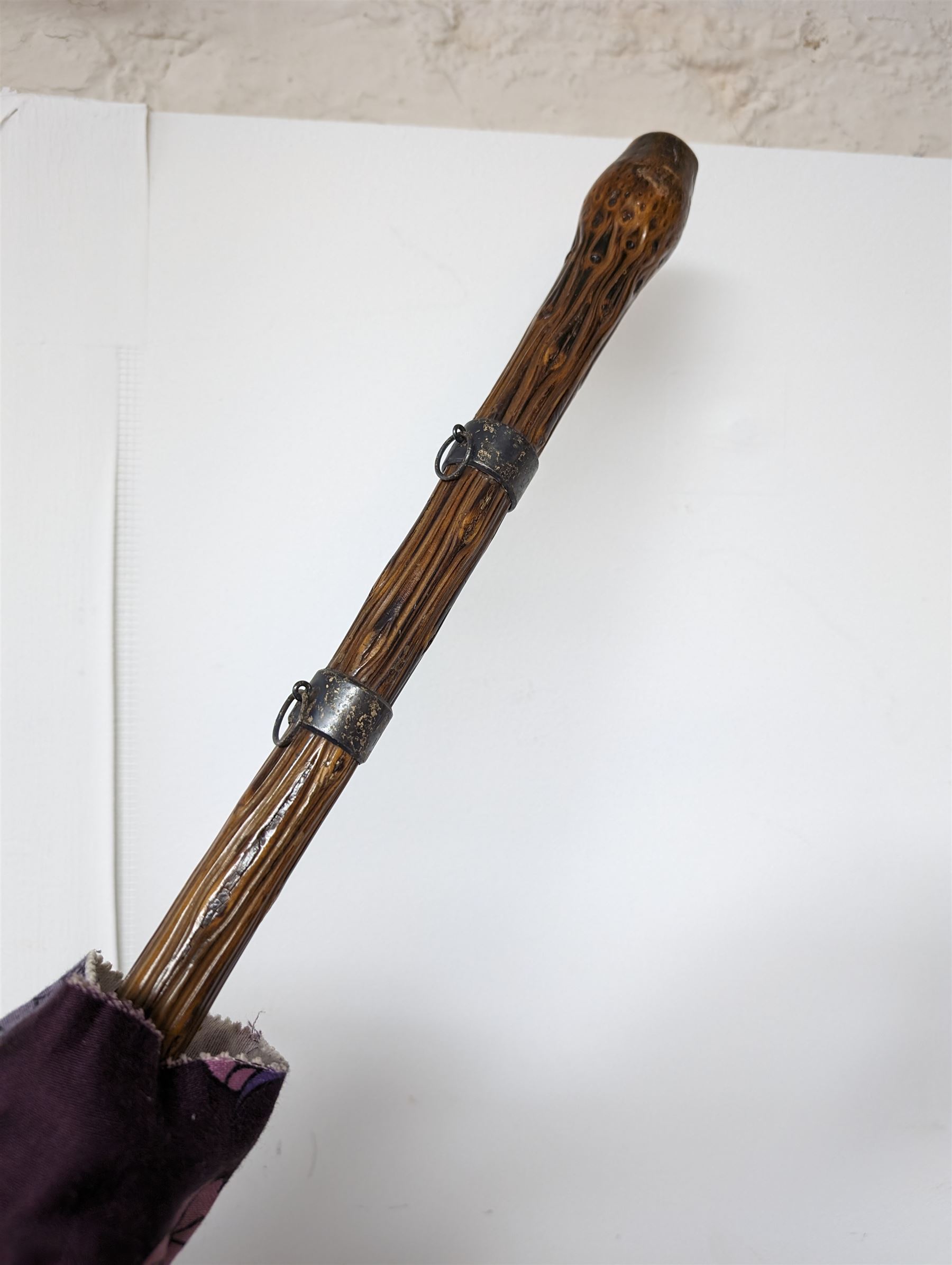 Pull along wicker basket on wheels, with cane handle, together with a silver mounted wooden umbrella and a one other umbrella, basket inlcuding handle H103cm