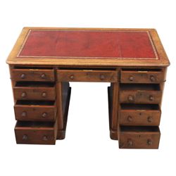 Victorian mahogany writing desk, featuring inset tooled red leather top, raised on two pedestals, nine drawers with figured veneer fronts