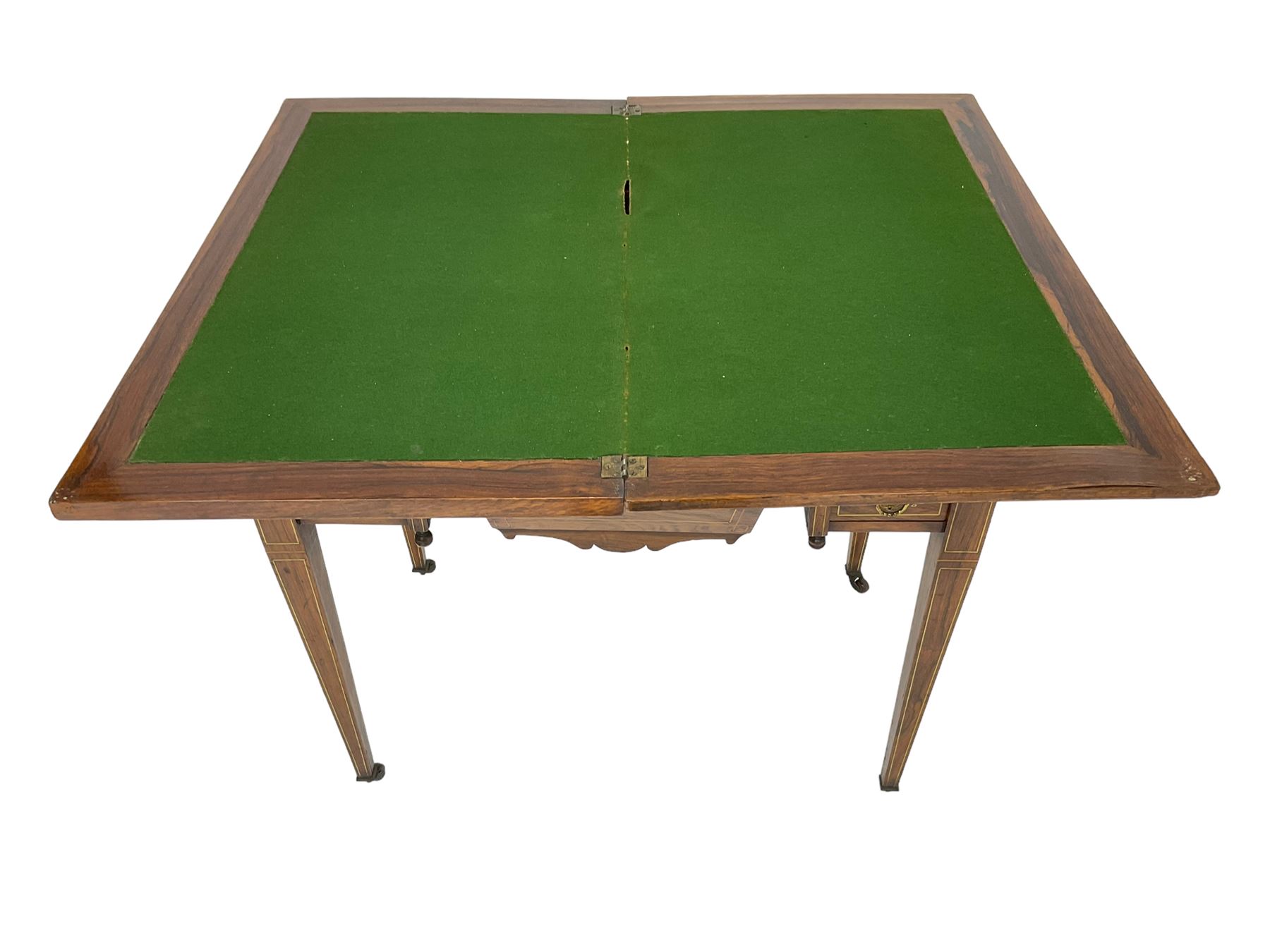 Edwardian inlaid mahogany games or work table, rectangular fold-over top inlaid with stylised dragon ivorine decoration and stringing, fitted with one long flanked by four small drawers over sewing compartment drawer, raised on square tapering supports with castors