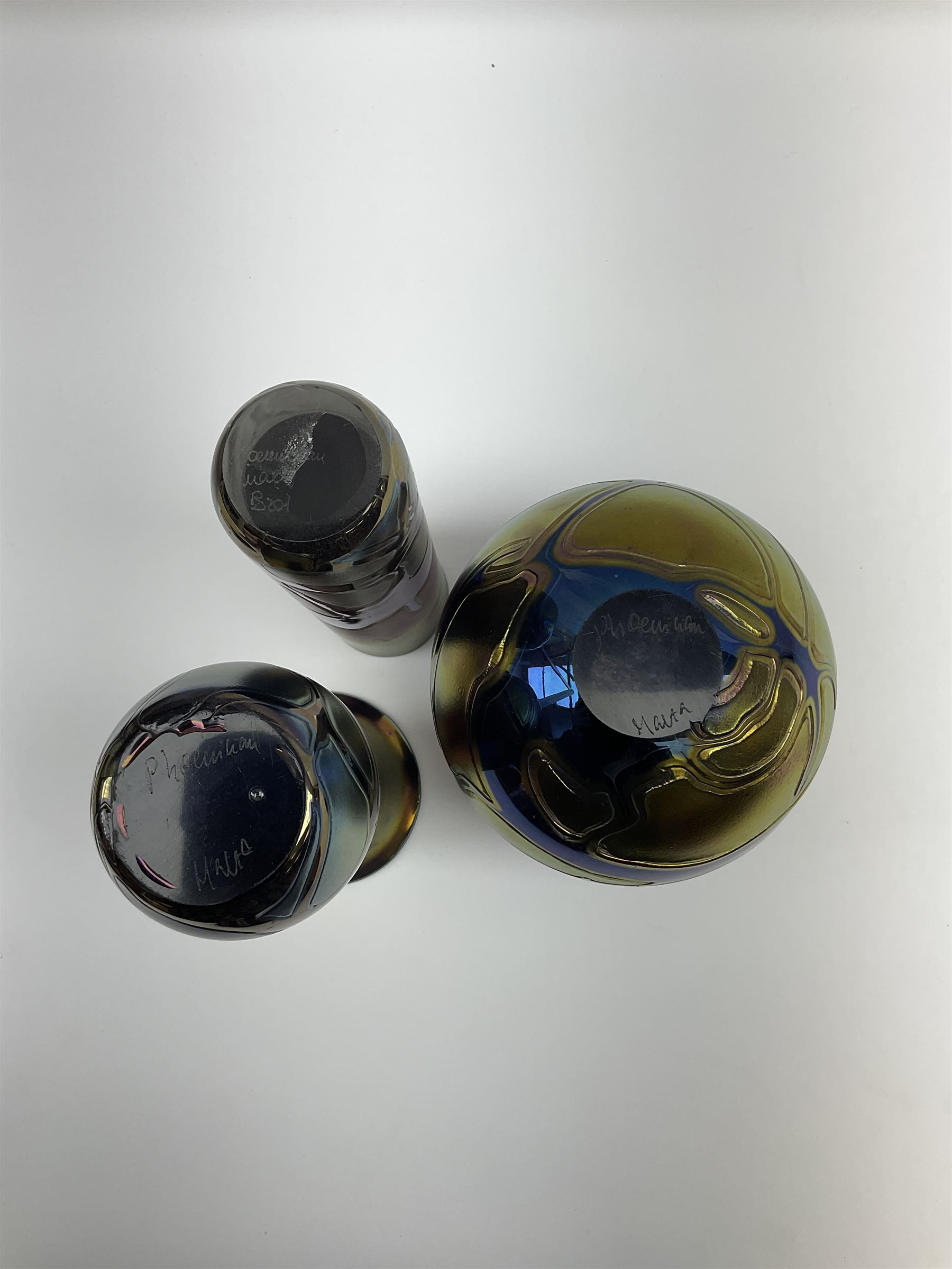 Group of Phoenician Malta art glass vases, all decorated with iridescent amethyst swirl pattern, comprising a spherical example, cylindrical example and baluster shaped example with flared rim, all signed beneath, tallest H20.5cm