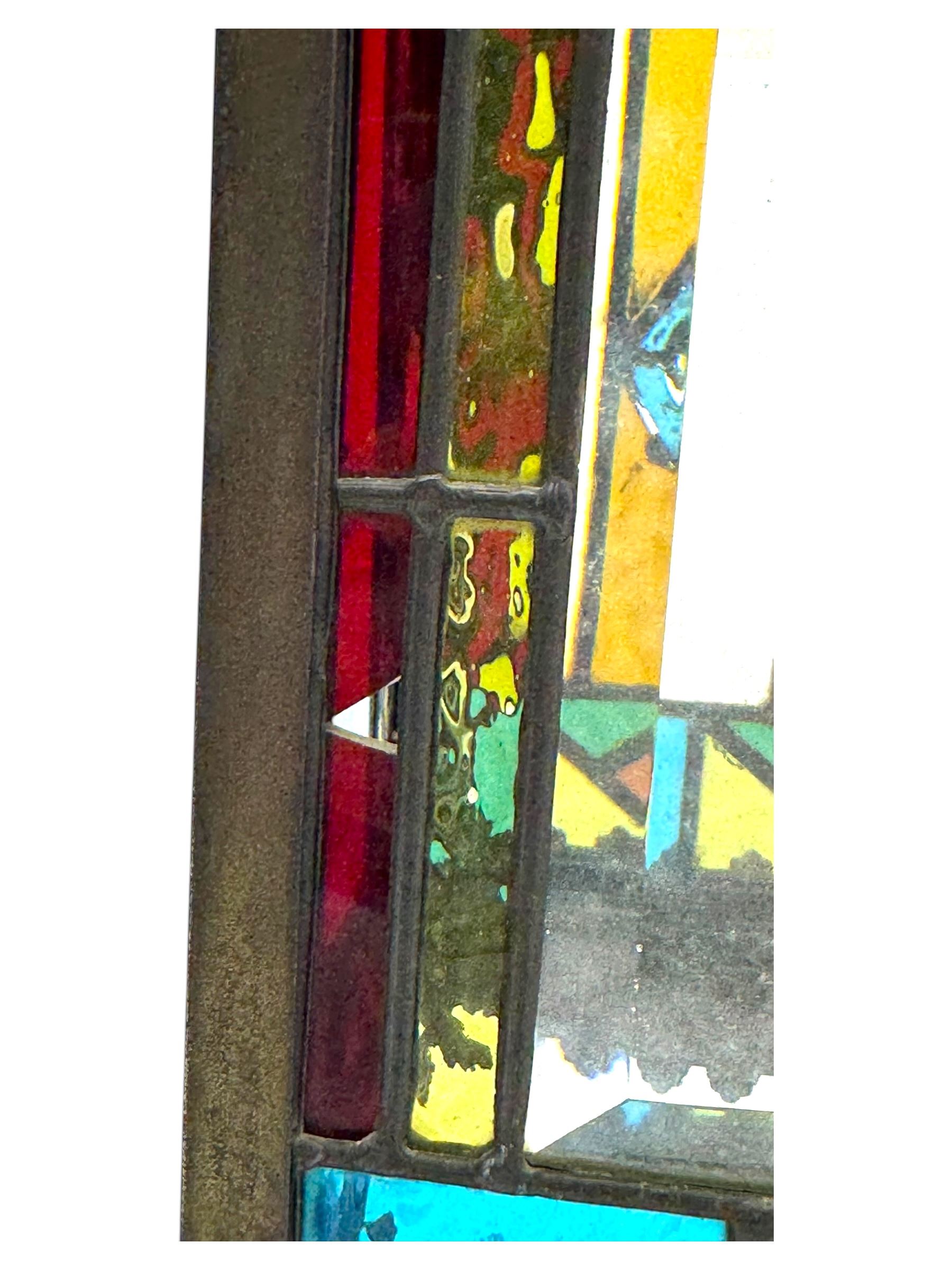 20th century Gothic design stained glass and brass hall lantern, with ornately decorated frieze and apron, with geometric coloured glass panels and eight rectangular bevelled glass panels, with bell shade, wired for electricity 