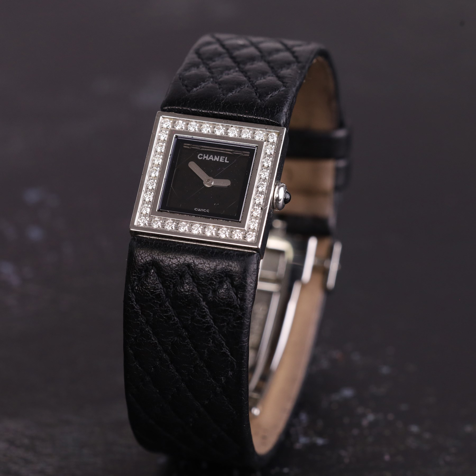 Chanel Matelassé ladies diamond stainless steel quartz wristwatch, black quilted dial, with round brilliant cut diamond bezel, back case No. 77835 and dated 2003, on quilted leather strap with fold-over-clasp 