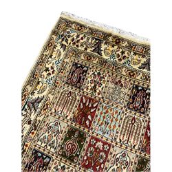 Persian Heriz design rug, ivory ground with rectangular panels each depicting garden scenes of tree of life, plants and Boteh motifs, the guarded border decorated with wildlife and bird scenes