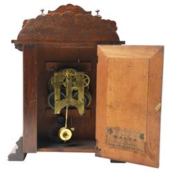Late 19th century-8-day American Ansonia mantle clock, in a carved oak case with an enamel dial and gilt dial bezel, twin train spring driven movement striking the hours on a coiled gong. With pendulum.