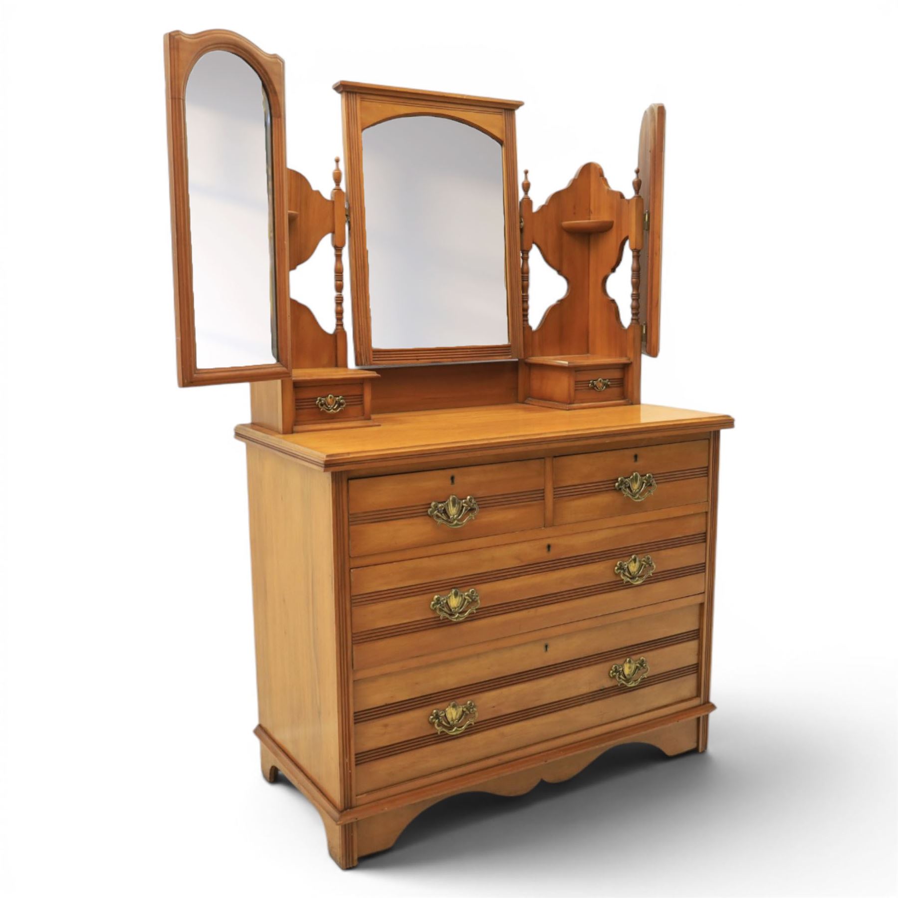 Edwardian satinwood dressing chest, rectangular moulded top over two short and two long drawers with brass drop handles, raised mirror back with arched central plate flanked by hinged side mirrors, small fitted trinket drawers and shaped pierced side supports with turned uprights