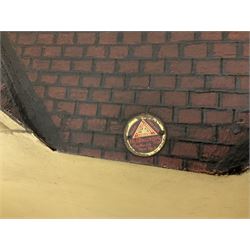 Large Tri-ang No.93 doll`s house in the 'Stockbroker's Range' c1935; two-storey double-fronted Tudor design, half timbered gables, two-storey bay windows, cream and mock shrubbery to front, opening metal framed windows with green shutters, red simulated tiled roof with chimney, integral garage with opening doors, front elevation has four hinged doors opening to reveal two bedrooms with fire places, living room, bathroom and kitchen with built in dresser and sink, entrance hall and staircase, side entrance with porch and seat and sun dial over on chimney stack; some wiring for electrical lighting; metal Tri-ang Toys disc verso; comprehensively furnished H66cm L117cm D43cm