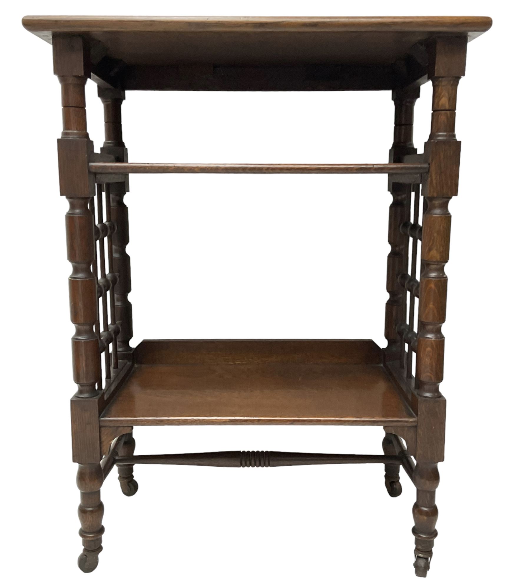 Late 19th century oak three-tier stand or bookcase, on turned supports with lattice sides, on turned feet with castors