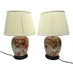 Pair of lamps of baluster form, decorated with daffodils upon a red ground, raised upon circular base, including shades H53cm