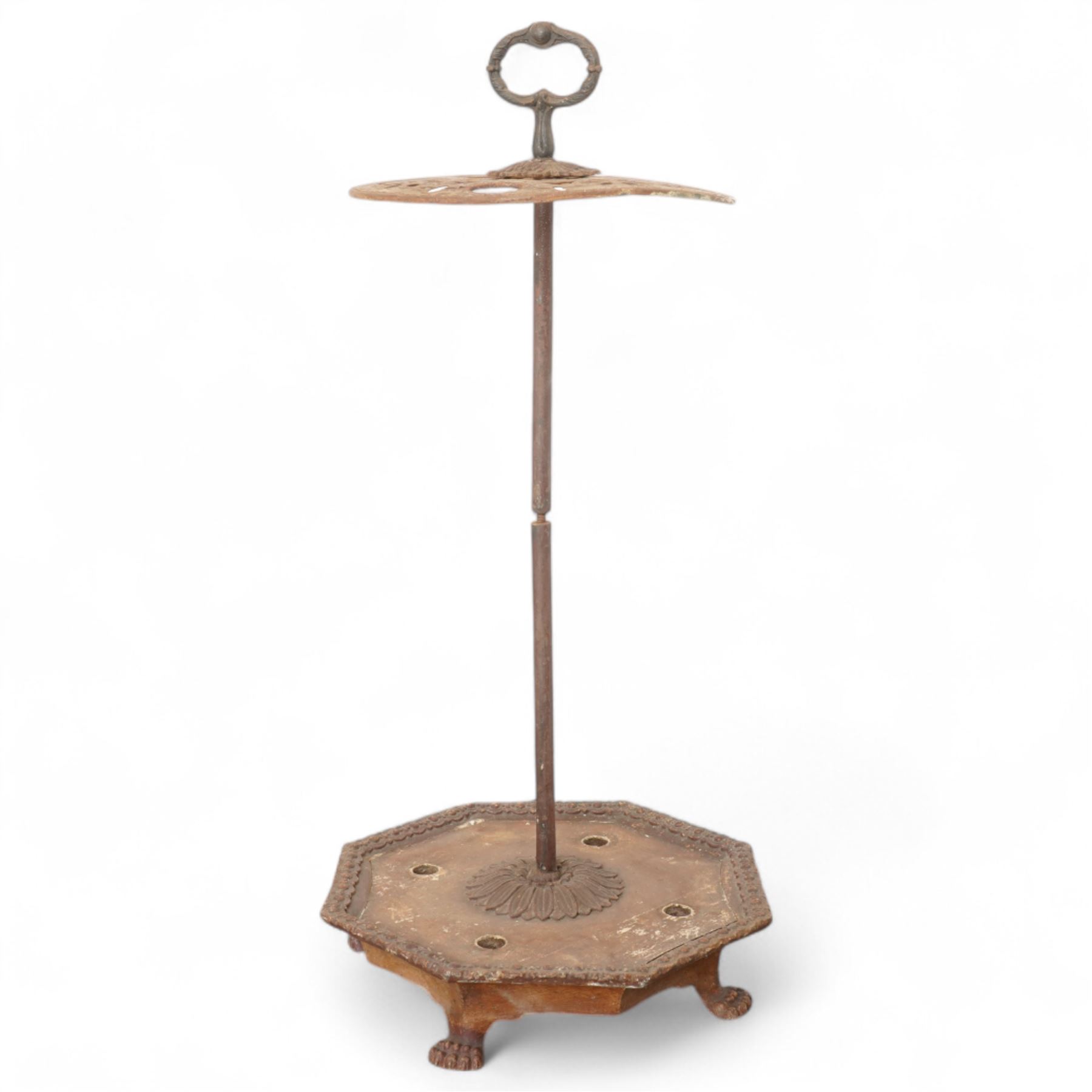 Victorian cast iron cane or stick stand, the top with a large loop lifting handle and floral design above geometric pierced decoration, central vertical rod, and octagonal base with lion paw feet