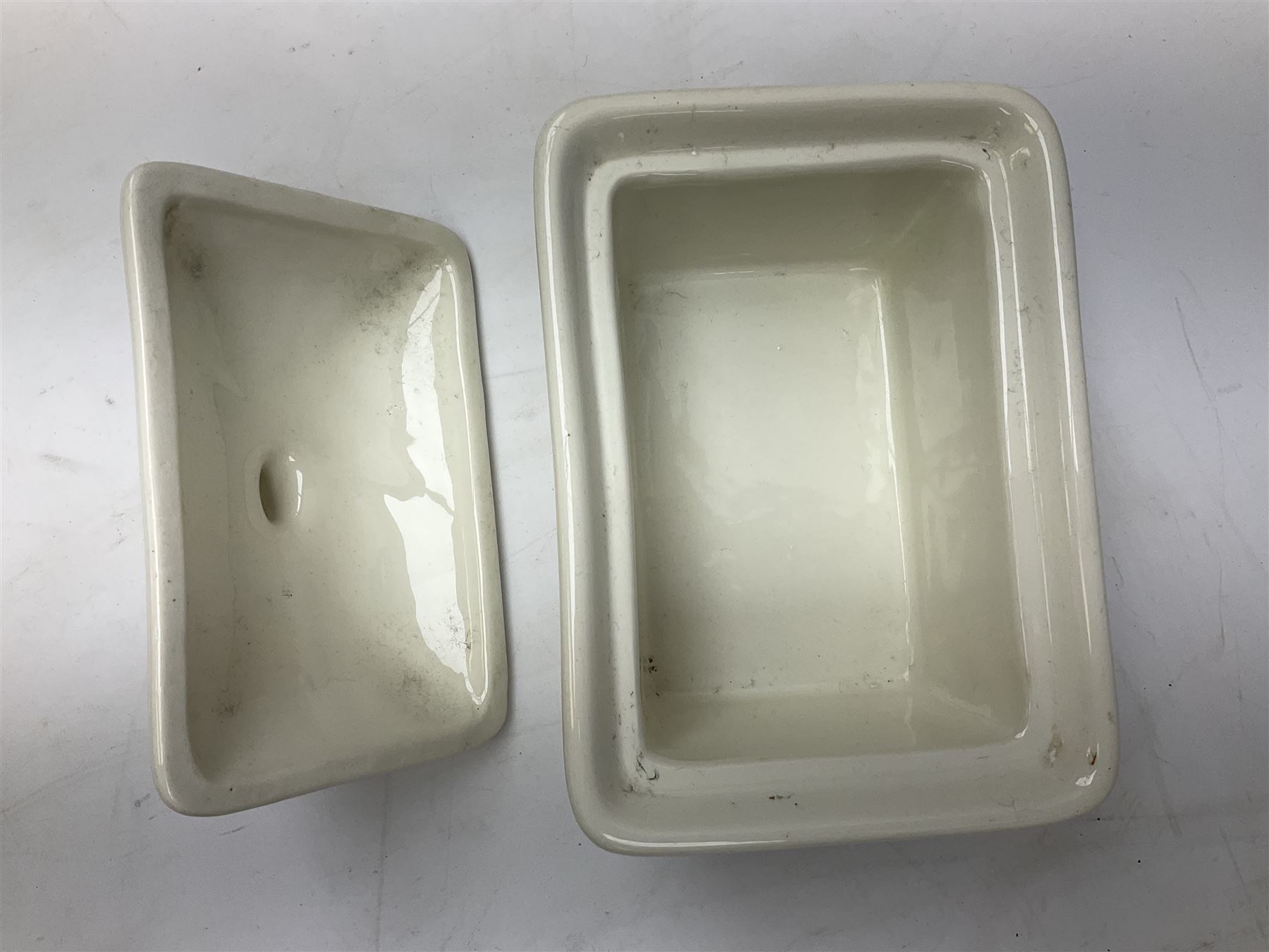 Emile Henry covered casserole dish of oval form in two tone brown and cream, no. 03.06, together with cast iron Nomar twin handled lidded casserole dish of oval form in navy, and other ovenware including Flintware ICTC, largest L35cm