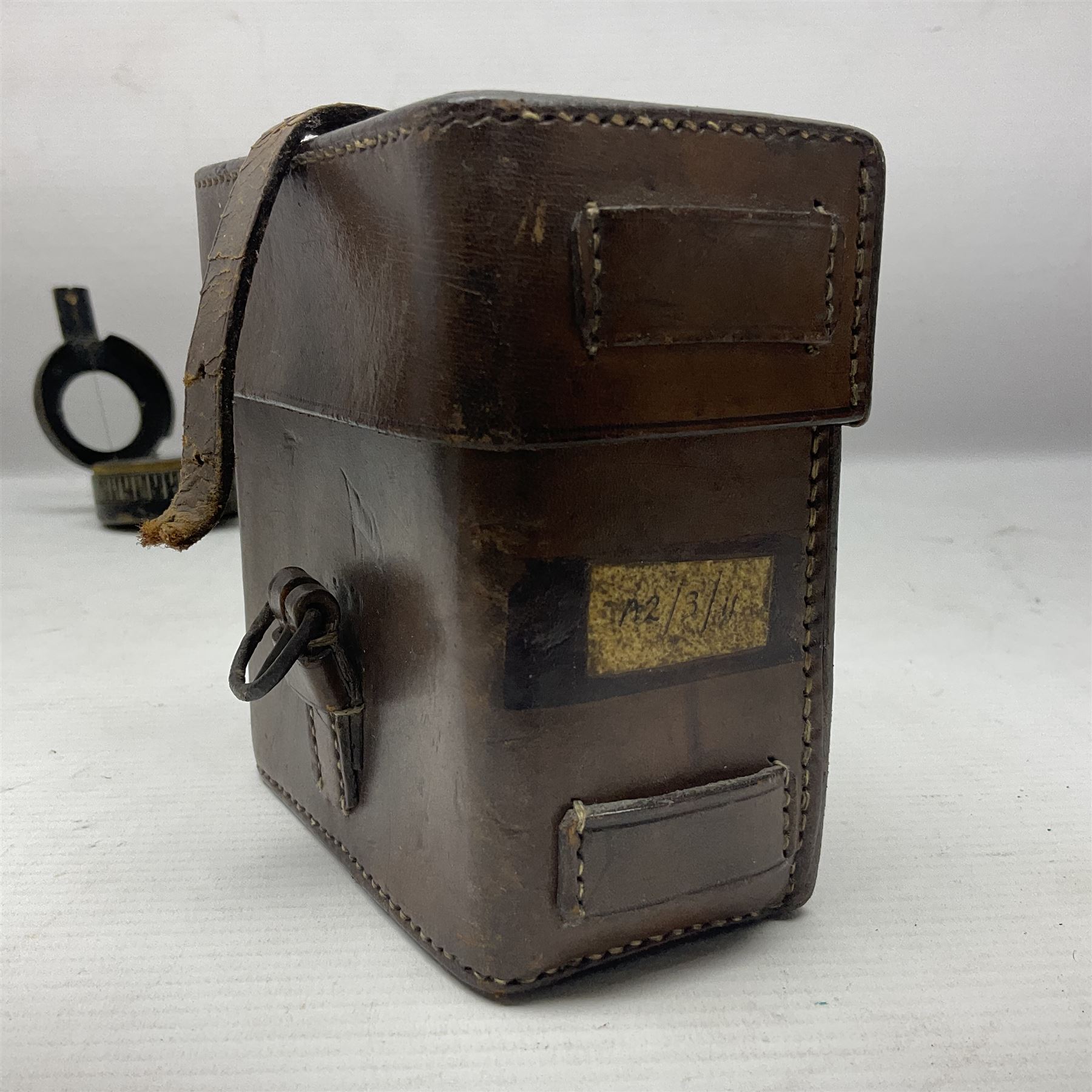 WWII British marching compass, the black lacquered brass case inscribed T.G.Co.Ltd. No.B100228 (broad arrow) 1941 Mk.III; and a ship's brass cased clinometer, the silvered dial marked R(arrow)L, D9cm; in leather carrying case (2)