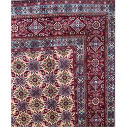 Northwestern Persian Hamadan carpet, hand-knotted, ivory field with an all-over Herati design of rosettes and serrated leaves within multiple borders, madder red with angular vine and rosette motifs, 375cm x 271cm 