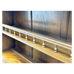 Large mid-20th-century oak dresser with two astragal glazed doors between gallery shelf and lower shelf, with three short drawers and lower section with four drawers and three double-panelled linen-fold hinged cupboard doors 