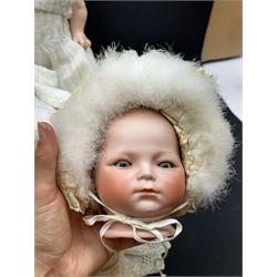 Two German bisque head dolls, to include a Franz Schmidt example with blue glass eyes and an Armand Marseille 590 example with applied hair, together with a Schoenau & Hoffmeister bisque doll's head, pair of doll's hands and a collection of clothing