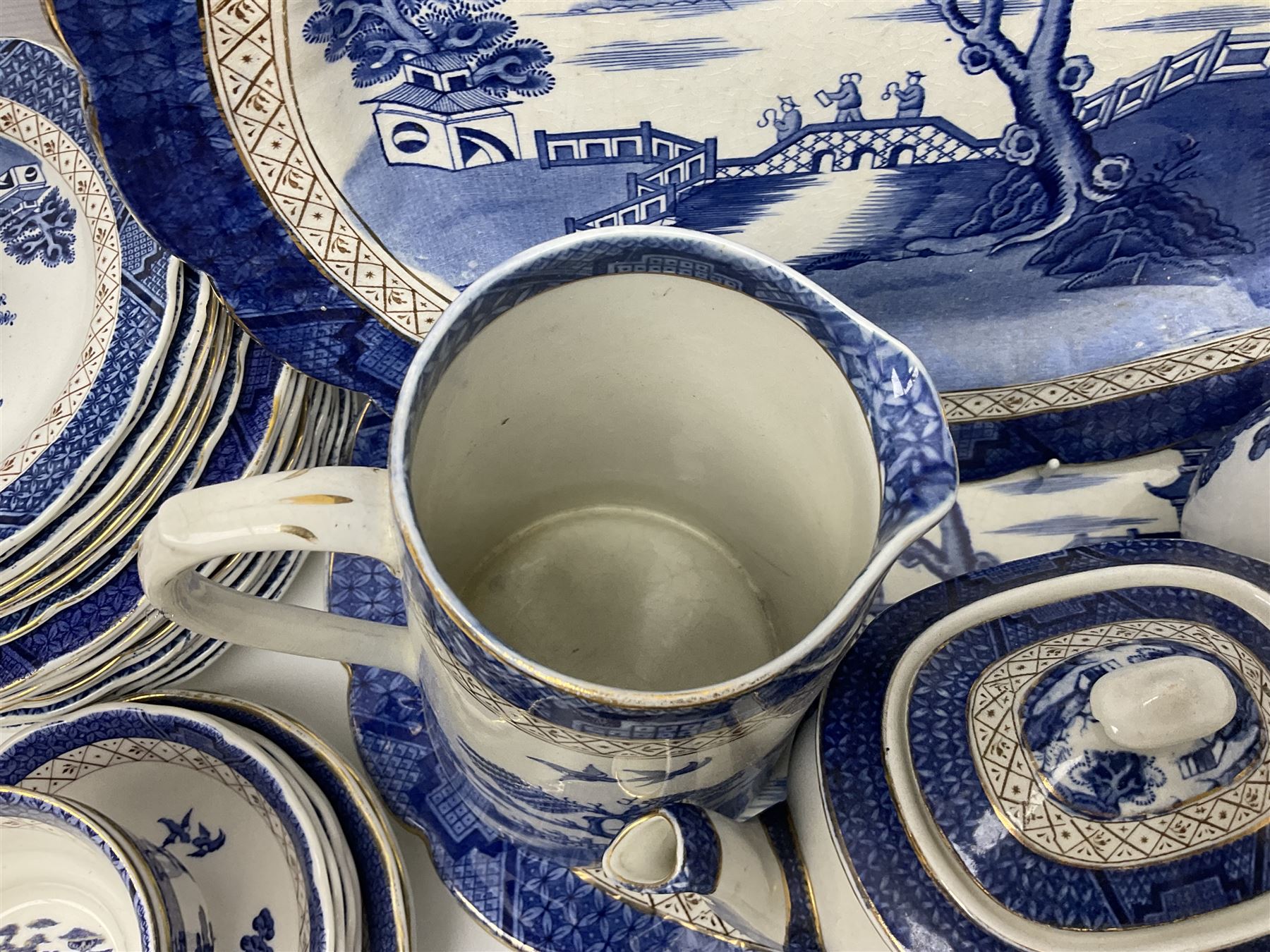 Booths Real Old Willow pattern part tea and dinner service, to include two meat platters, cake stand, teapot, two jugs, sugar bowl, sauce boat, teacups and saucers and a collection of plates and bowls