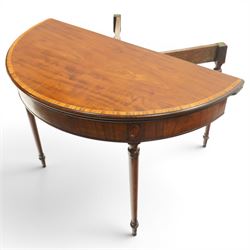 Georgian mahogany demi-lune card table, the lunette shaped top with cross-banded and boxwood-strung edge, opening to reveal baize-lined interior and supported by rear gatelegs, over a banded frieze with applied oval plaques, raised on turned and tapering supports