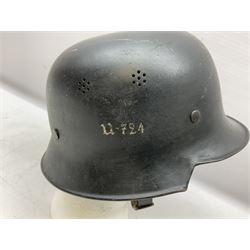 WW2 German steel combat helmet with eagle insignia to one side and U-724 to the other, leather liner marked No.56 and leather chin strap; indistinctly stamped to the skirt '*ahl'