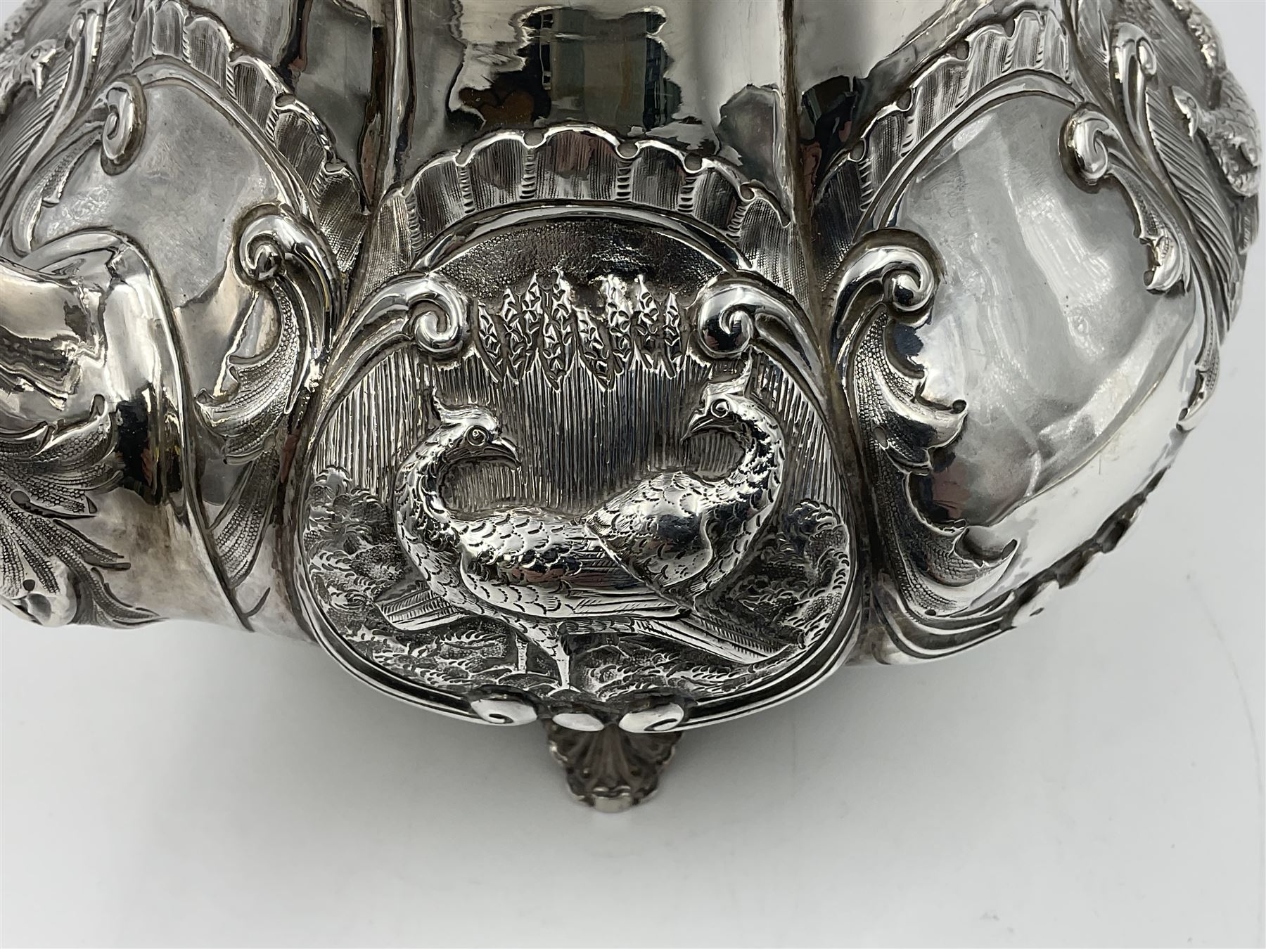 Victorian silver three piece tea service, comprising teapot, twin handled open sucrier, and milk jug, each of bellied form with acanthus capped scroll handles, the sides embossed with alternating scroll edged vacant panels and panels containing a pair of birds, upon four palmette feet, the teapot with ivory insulators to handle, and bird finial to the hinged domed cover, hallmarked William Hunter & Son, London 1861, teapot H19cm, including handles sucrier H13.5cm, including handle milk jug H12cm

This item has been registered for sale under Section 10 of the APHA Ivory Act