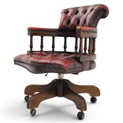 Captains swivel desk chair upholstered in oxblood leather, buttoned back and seat, shaped arm bow raised on turned spindles, five spoke base raised on castors
