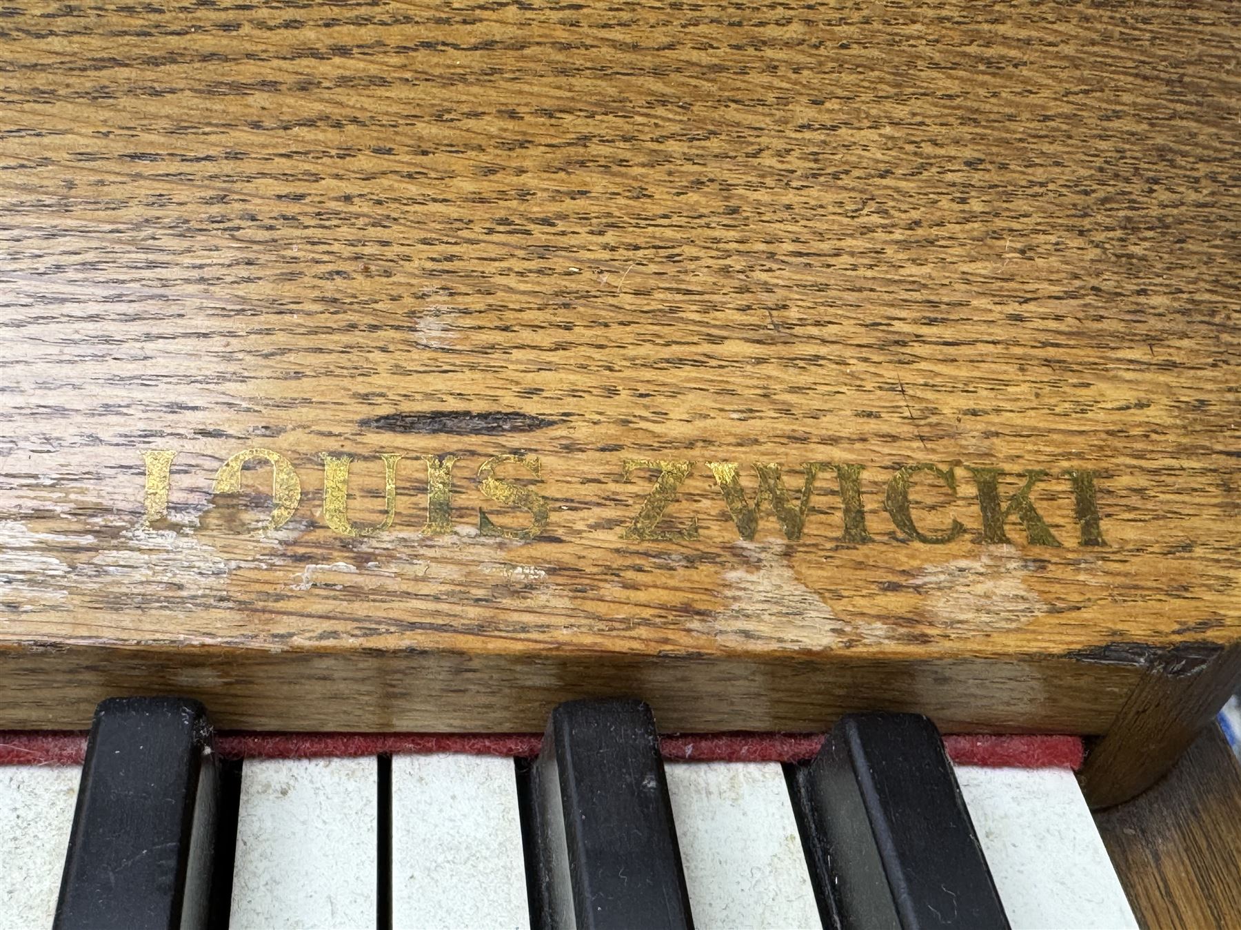 Louis Zwicki - mid-20th century oak cased compact piano, fitted with a folding music rest and full keyboard, dual brass pedals