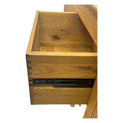 Contemporary light oak sideboard, chamfered rectangular top over two central bevel-edged drawers, flanked by two recessed panelled cupboards enclosing shelving, on square stile supports