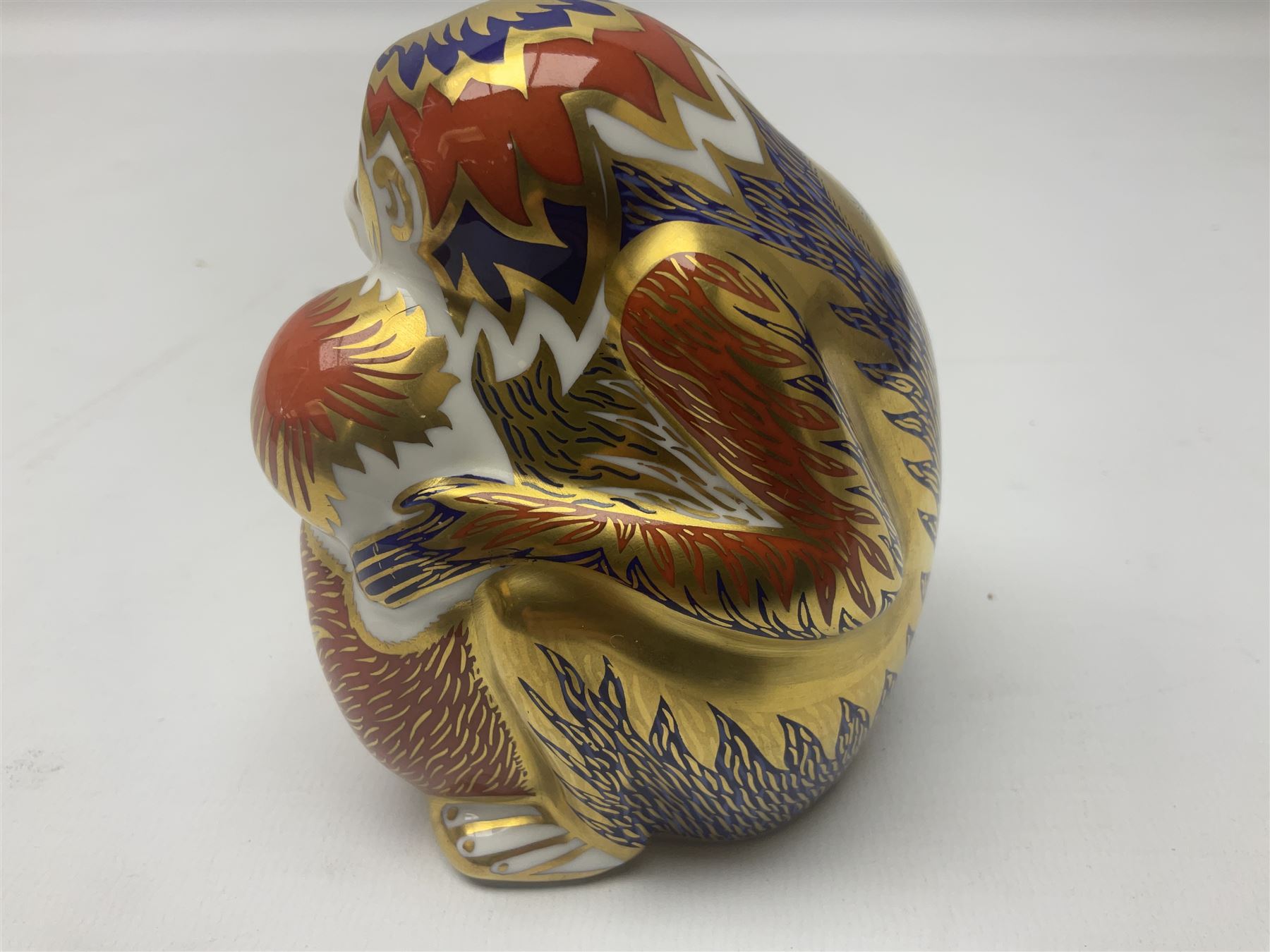 Three Royal Crown Derby paperweights, comprising Macaque, with gold stopper and original box, Monkey and Baby, with silver stopper and original box and Dragon with silver stopper, all with printed mark beneath  