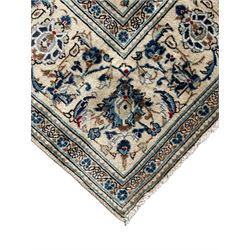 Persian Kashan ivory ground rug, the field decorated with trailing branches with leaves and palmettes, similar scrolling border, within floral pattern guard stripes 