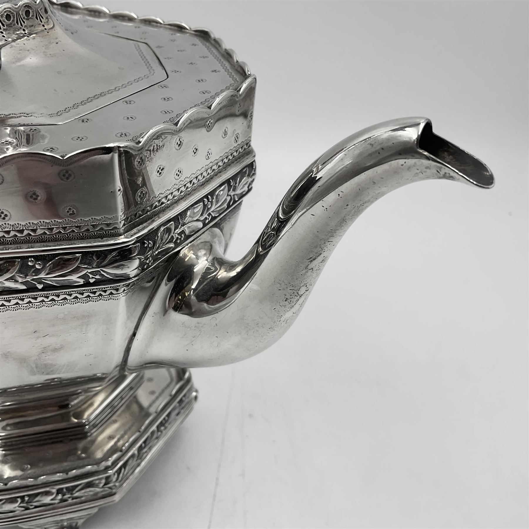 Victorian silver four piece tea service, comprising teapot, teapot stand, twin handled open sucrier and milk jug, each of octagonal form with foliate bud border and engraved decoration including crest to canted panels, and vacant panels, the teapot with ivory finial to the hinged cover and later wooden handle, hallmarked Edward Barnard & Sons Ltd, London1896, teapot including finial H15cm, milk jug including handle H16cm, teapot stand W11.5cm

This item has been registered for sale under Section 10 of the APHA Ivory Act