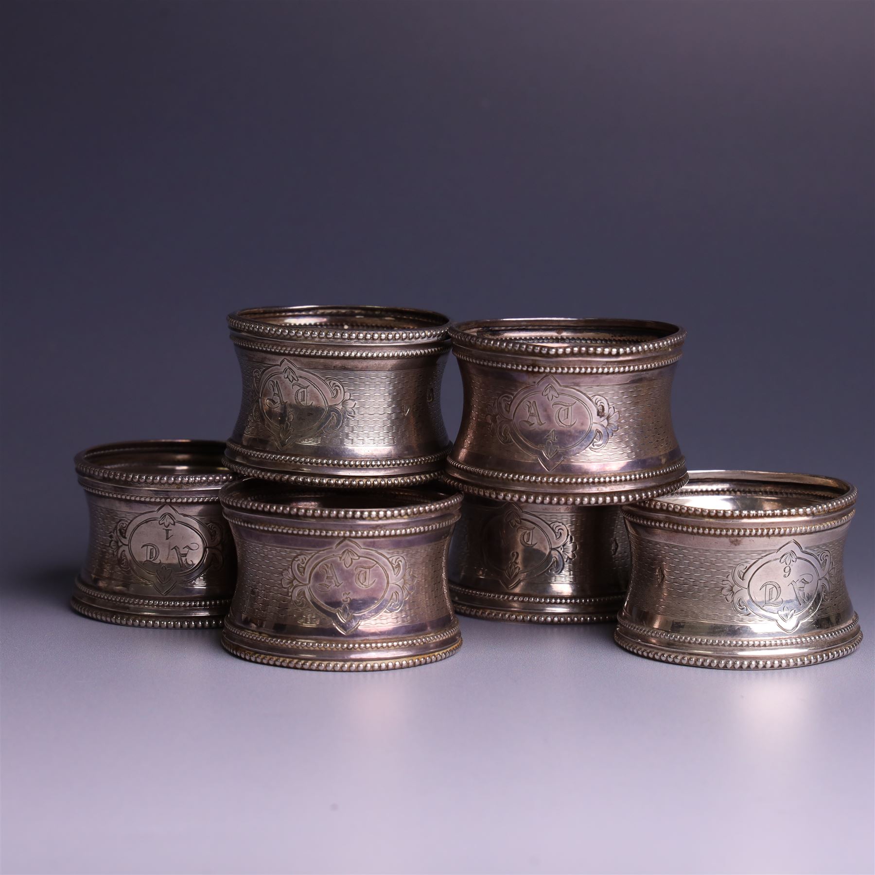 Six early 20th century French silver napkin rings, each with engraved initials, stamped with Minerva mark for 950 standard silver and maker's mark for Claude Doutre Roussel 