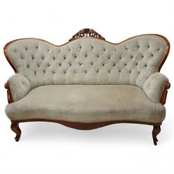 Victorian walnut double-ended settee, shaped cresting rail with foliate carved pediment, upholstered in buttoned sage green fabric, on cabriole feet
