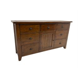 Stained pine rustic sideboard, rectangular top over seven drawers and single panelled cupboard, fitted with shell handles