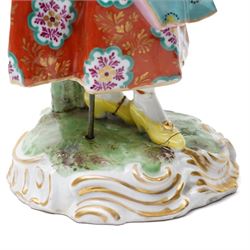 Pair of 19th century Samson of Paris figures of male and female itinerant milliners, each holding a basket with ribbons and flowers on rococo style gilt bases H33cm