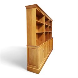 Philip Koomen (1953-) - Craftsman-made modern cherrywood large open
bookcase with a cupboard base, upper section with a
shaped cornice above three sections with two open
shelves, the lower section has three cupboards,
each with two panelled doors enclosing a single
shelf, raised on a plinth base