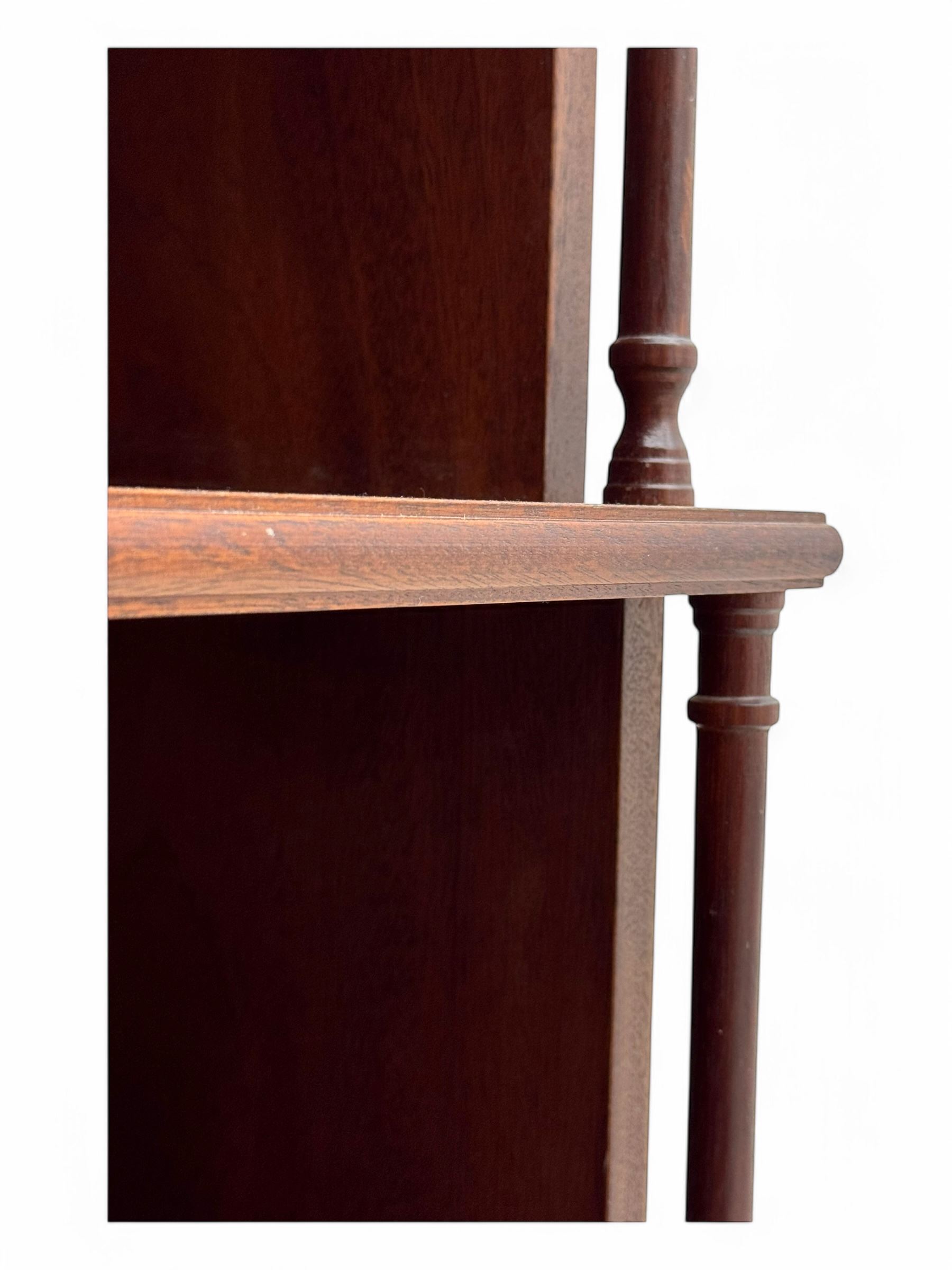 Mid-20th century mahogany open bookshelf, the rectangular top with a brass balustrade gallery, over three shelves each supported by turned column uprights, on shaped apron base