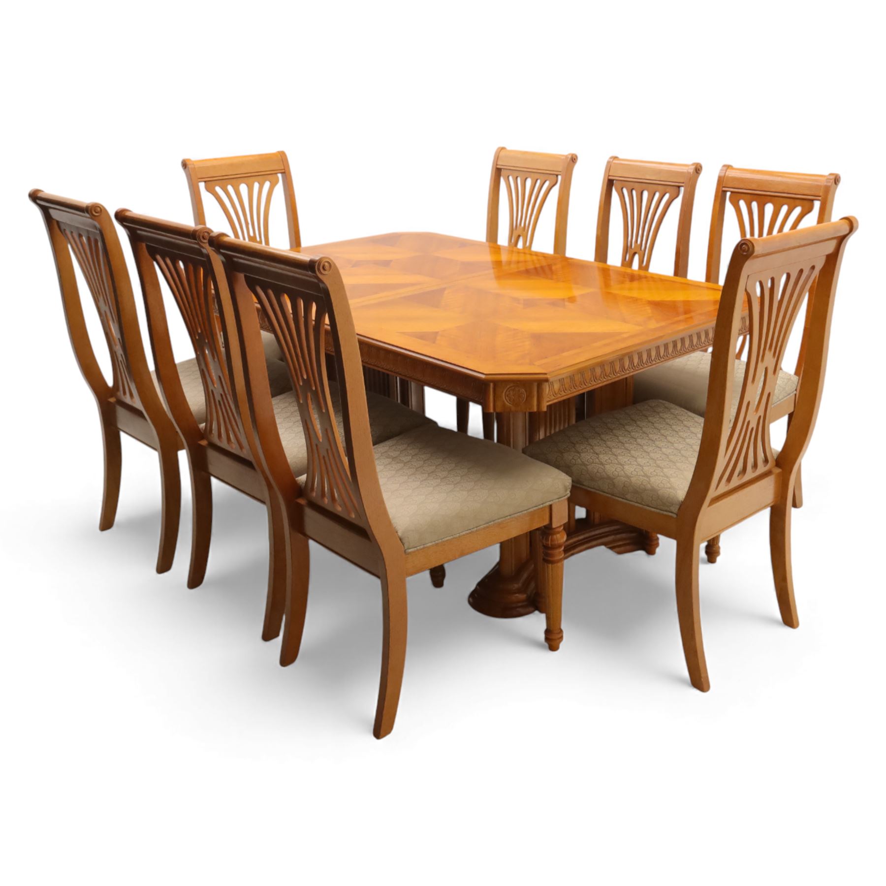 Late 20th century parquetry veneered extending dining table and eight chairs, the rectangular top with canted corners decorated with geometric parquetry panels, moulded edge frieze with repeating carved detail, raised on twin pedestal supports with fluted columns and shaped platform bases, the chairs with pierced splat backs and upholstered drop-in seats
Extends on a central leaf to 208cm