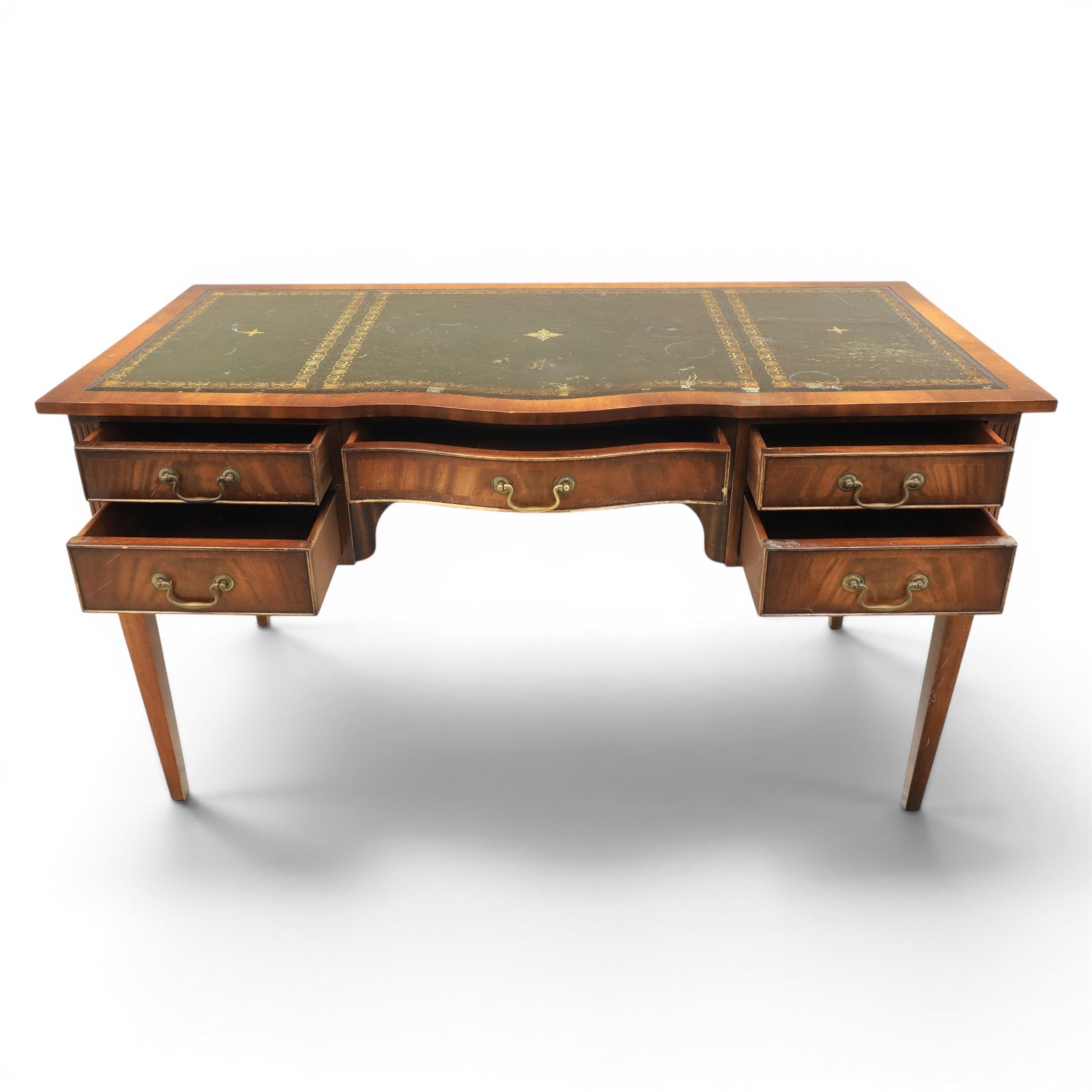 Regency style mahogany writing desk, serpentine front tooled green leather inset, slides to either side, central frieze drawer, flanked by a bank of two drawers, square tapering supports