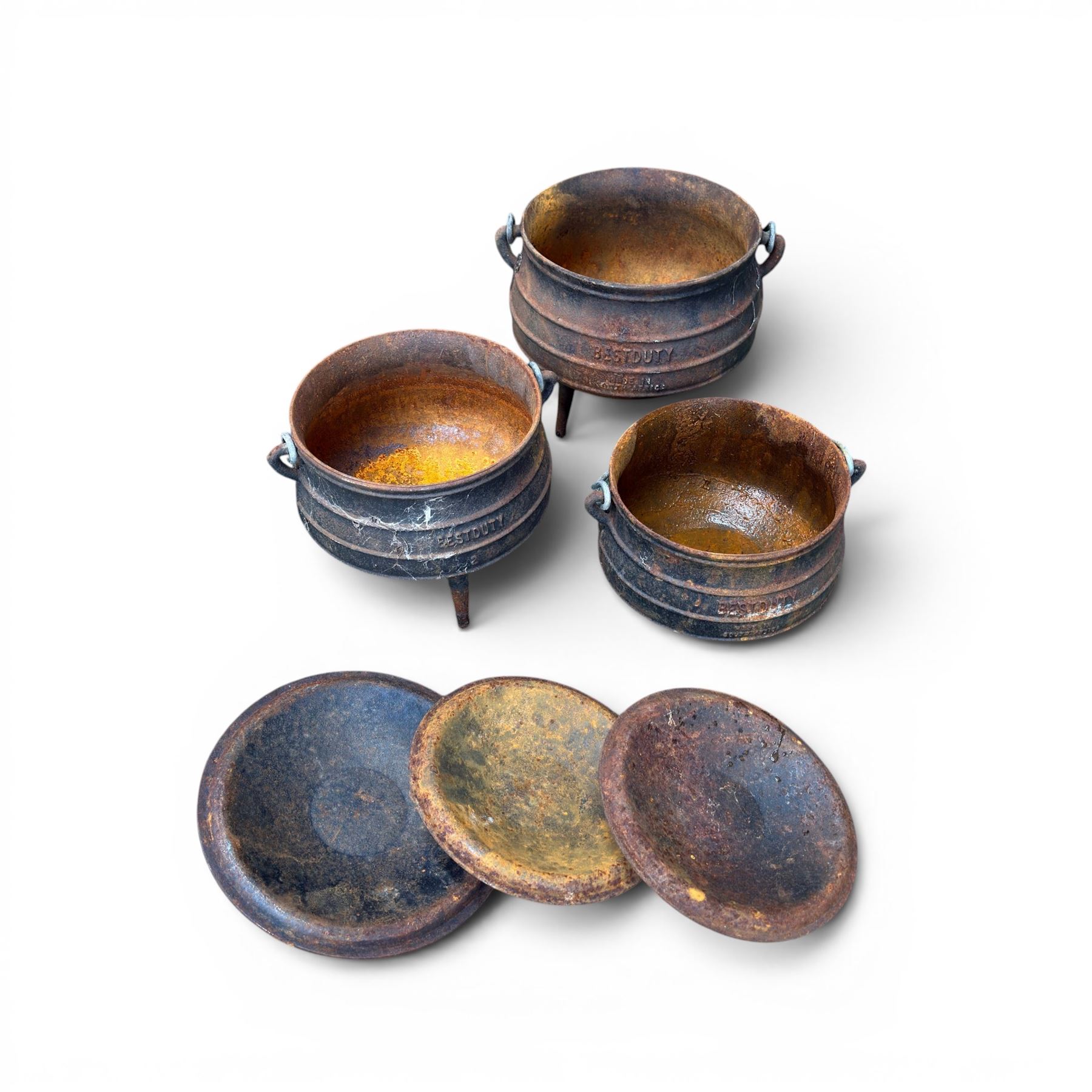 Three South African cast iron graduating cooking pots with lids and handles. Size shown for the largest