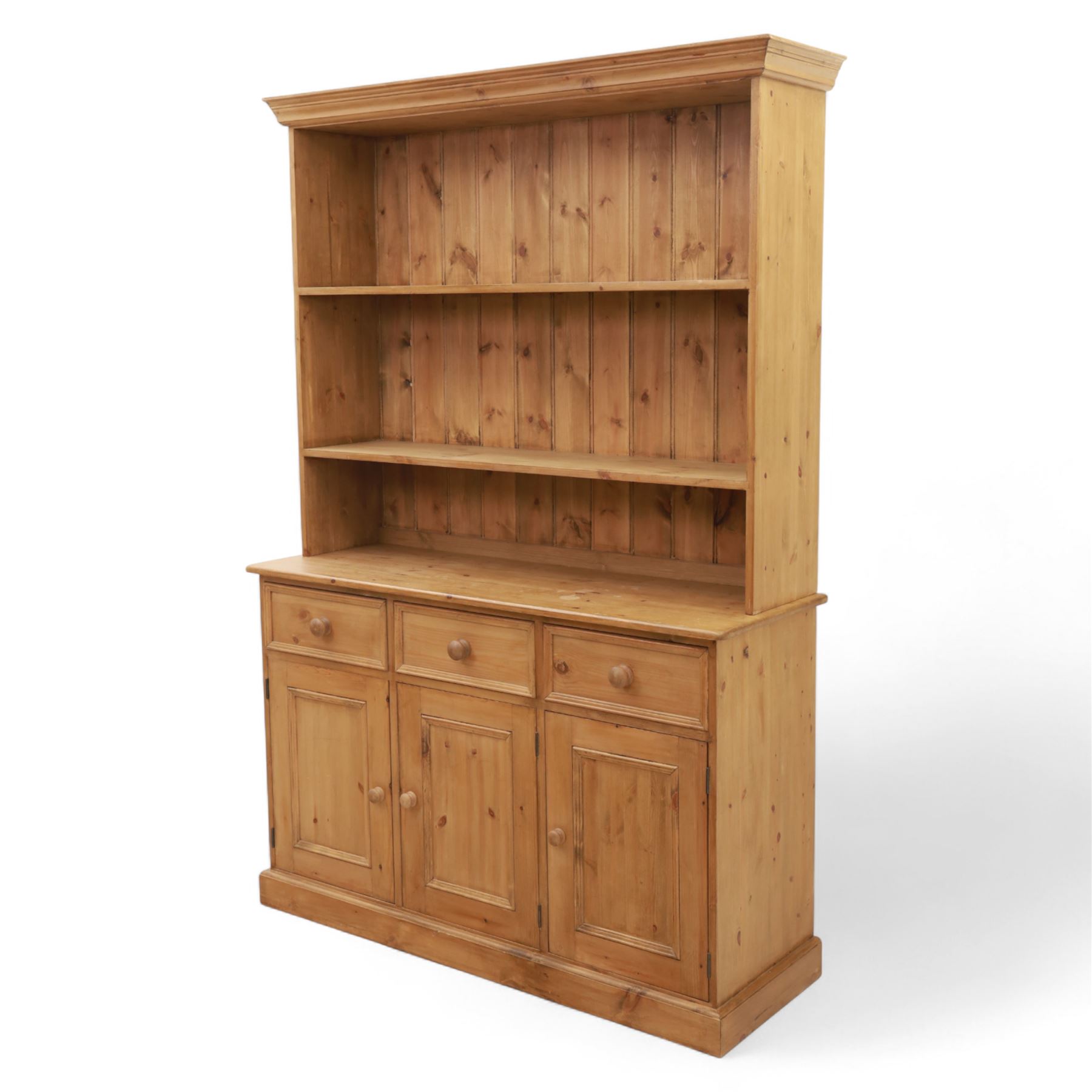 Late 20th century pine kitchen dresser, the upper section with open shelves and tongue and groove back, over a triple cupboard base with three drawers, turned wooden knobs throughout
